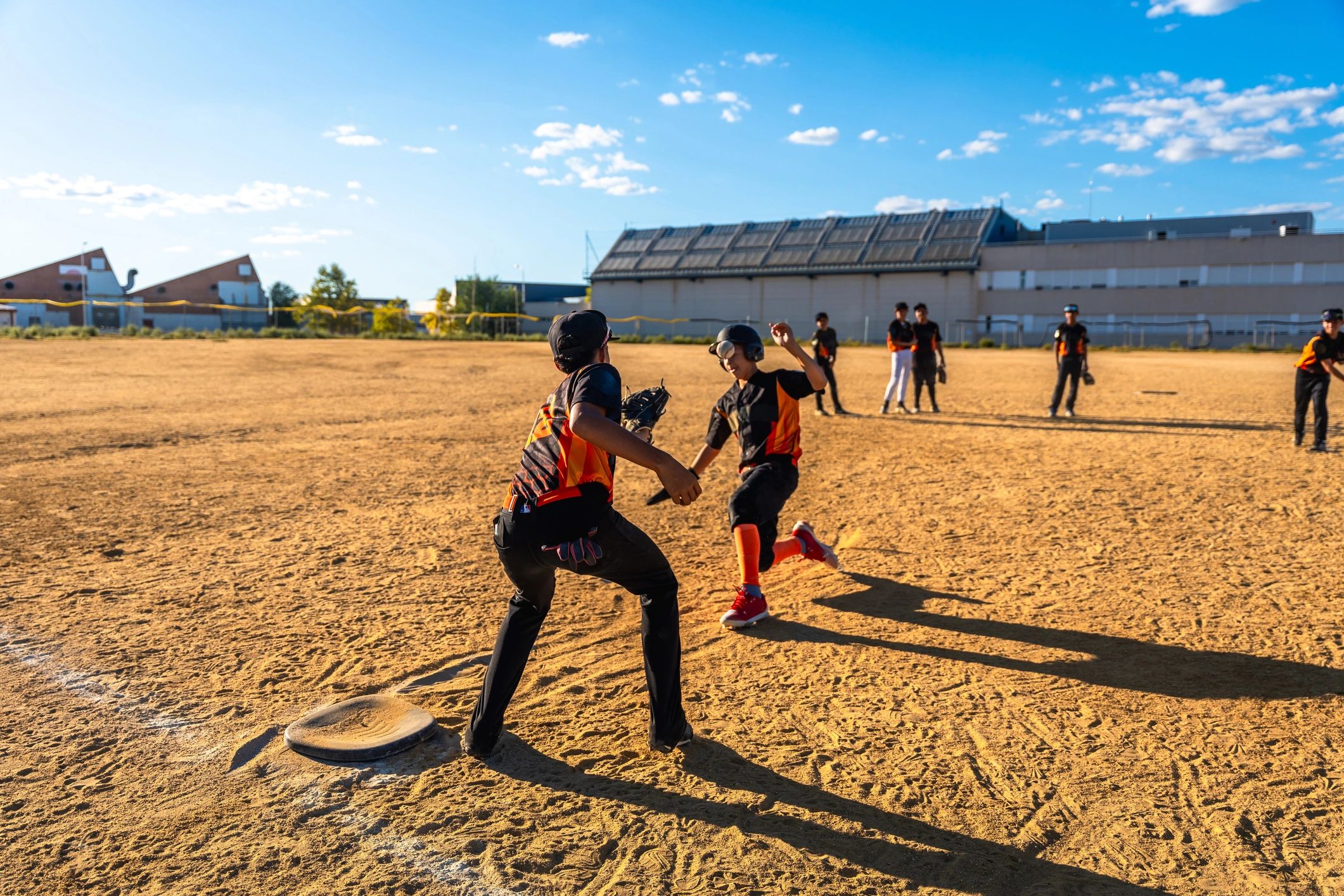 Youth baseball players running and tagging out on field